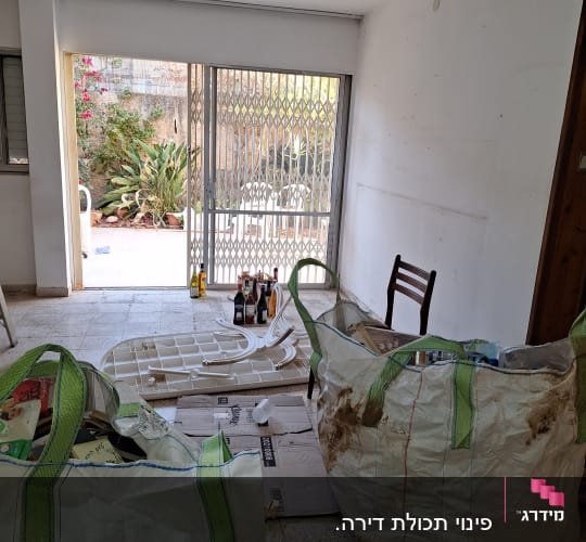 שקיות גדולות עם חפצים, בקבוקים על הרצפה